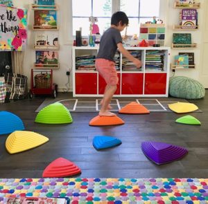 Child in play room balancing on stepping stone