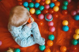 Baby surrounded by colorful plastic balls